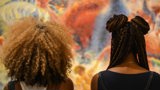 two women looking at painting with braids and afro hair